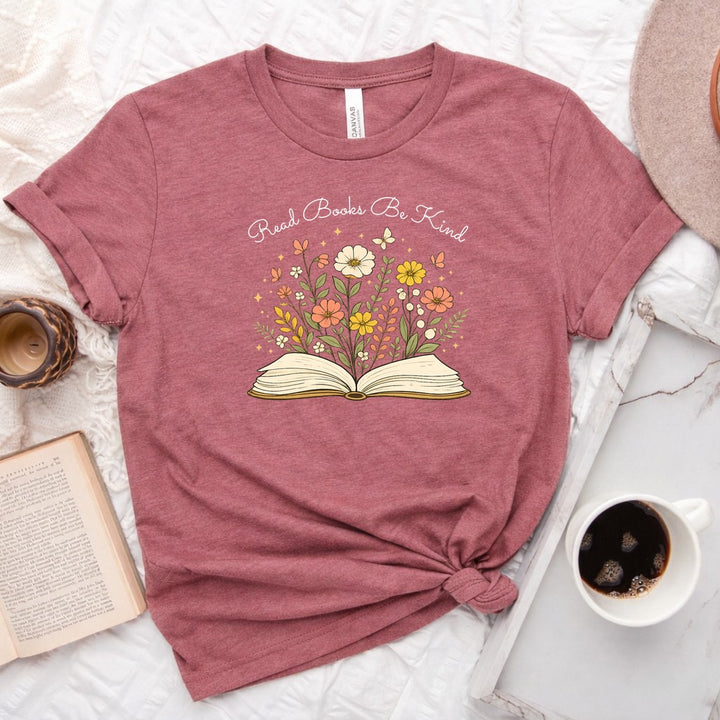 Unisex book lover tee featuring a vintage-style open book with wildflowers, cosmos, and butterflies blooming from the pages