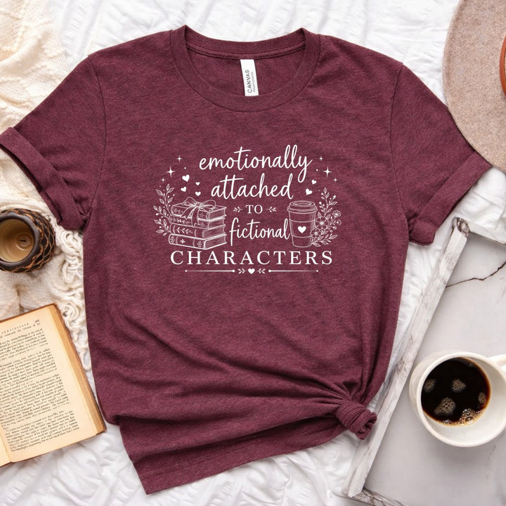 Emotionally attached to fictional characters bookish graphic unisex tee with stacked books and floral wreath design