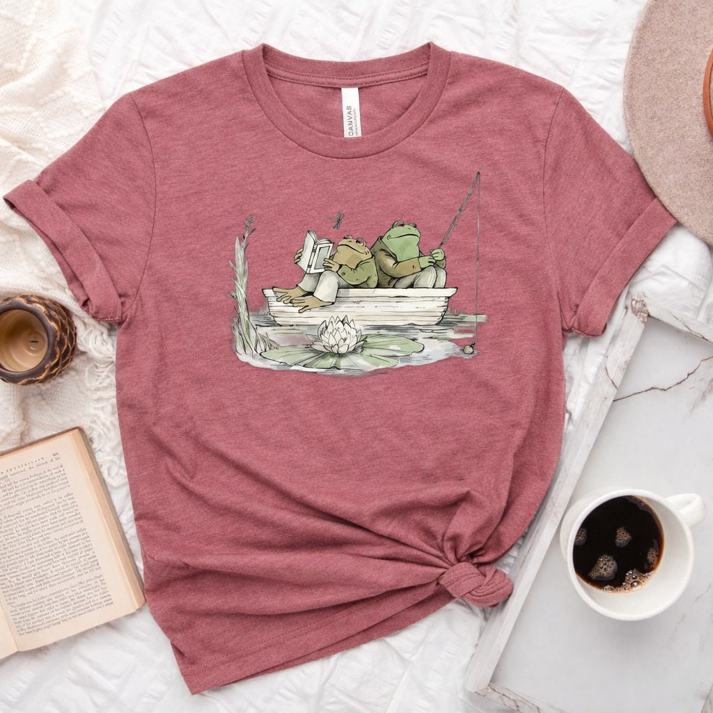 Frog reading and fishing graphic on a soft unisex crew neck tee, perfect for book lovers