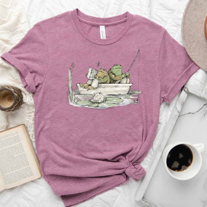 Frog reading and fishing graphic on a soft unisex crew neck tee, perfect for book lovers